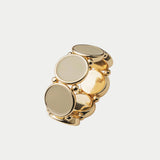 Elastiskt armband med runda plattor som har en guldkant i beige