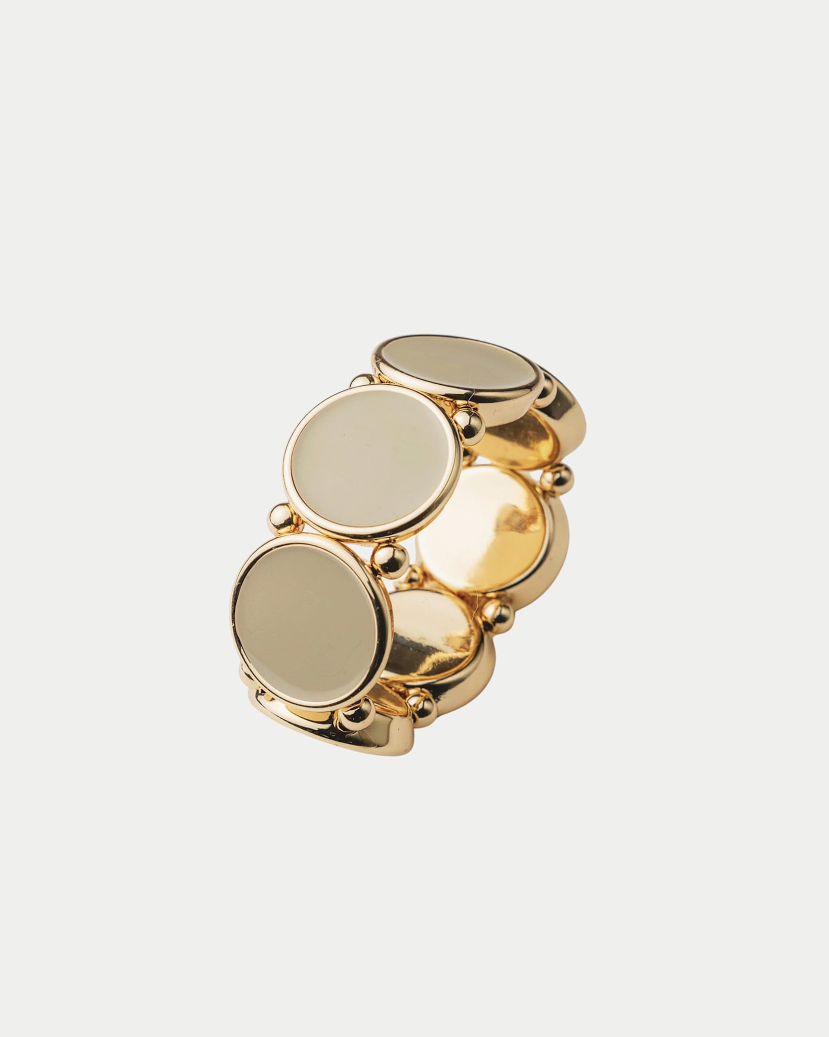 Elastiskt armband med runda plattor som har en guldkant i beige